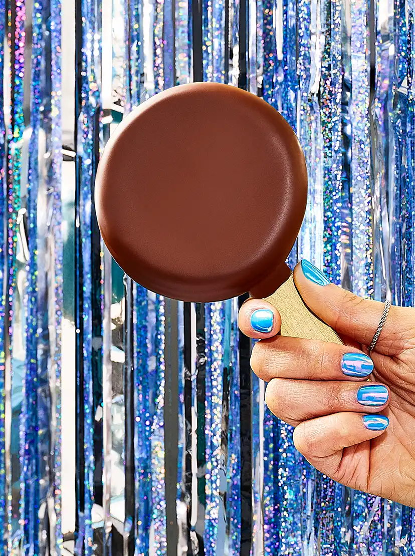 A hand holding a Dilly bar
