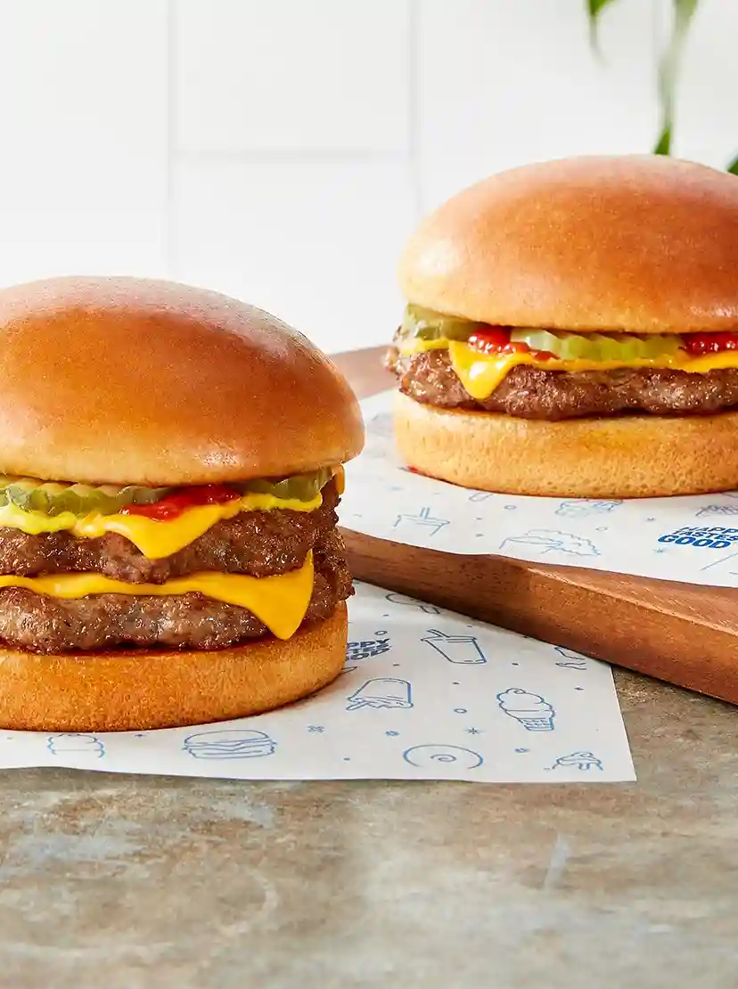 Numerous Original Cheeseburger Double and Single Signature Stackburgers placed on DQ burger  wrapping paperHappy Tastes Good