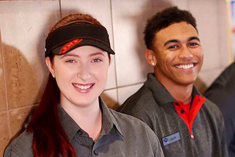 Photograph of two employees in uniform smiling