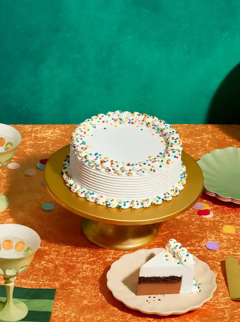 a table with a DQ cake and party supplies